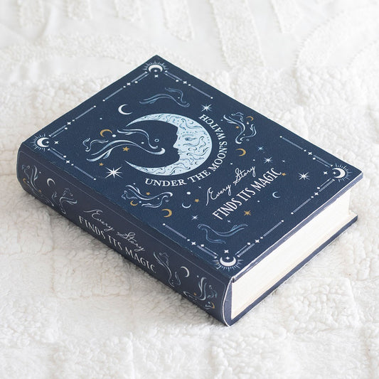 Decorative book with celestial design on a textured white surface