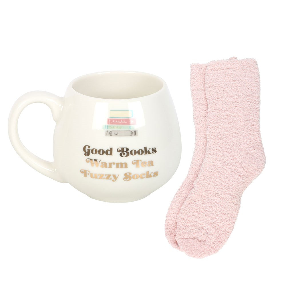 White mug with text and pink fuzzy socks on a white background