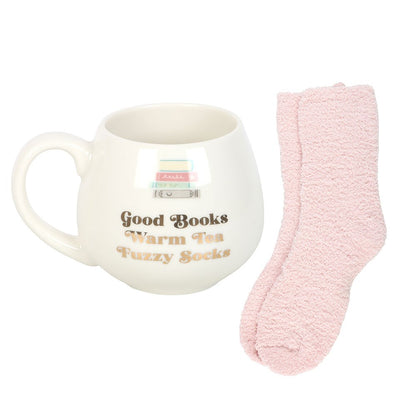 White mug with text and pink fuzzy socks on a white background