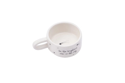 White ceramic candle holder with text on a white background