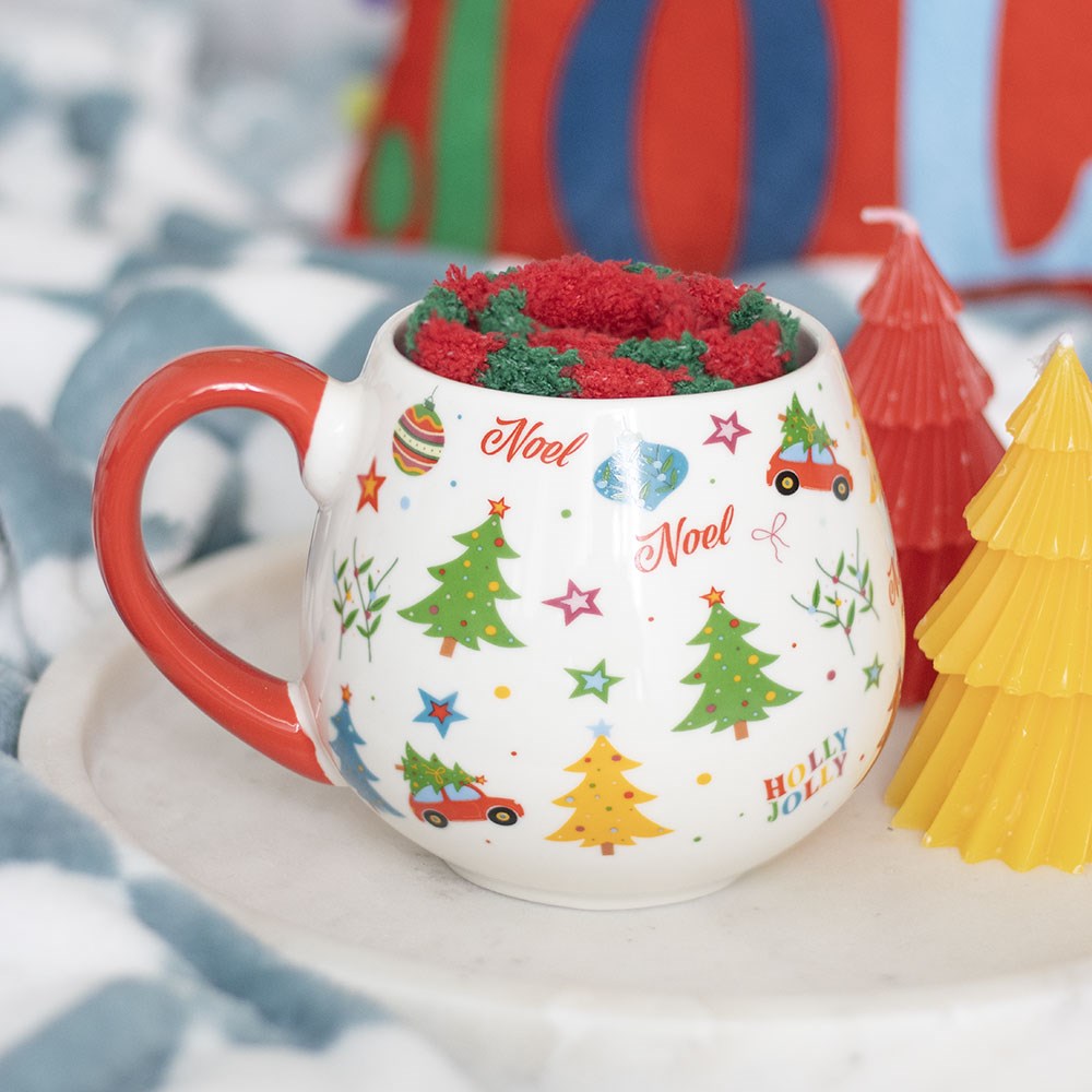 Decorative Christmas-themed mug with festive designs on a white surface.