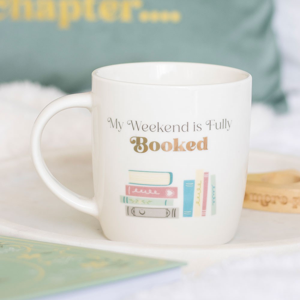 White mug with 'My Weekend is Fully Booked' text and book illustration.