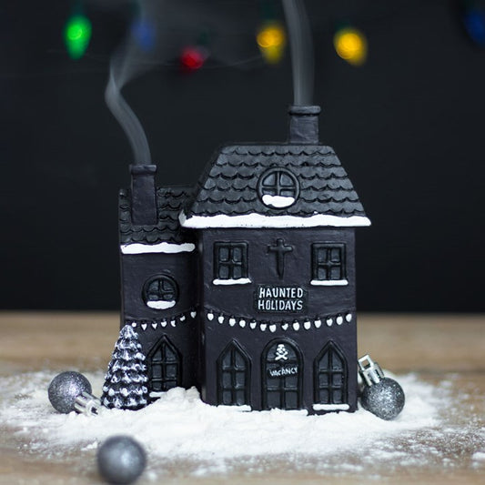 Black haunted house decoration with 'Haunted Holidays' text, surrounded by decorative elements on a dark background.