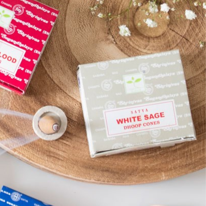 Box of incense White Sage droop cones on a wooden surface with a red box in the background.