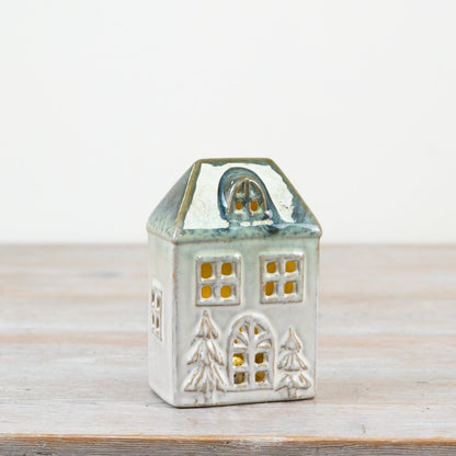 Ceramic house-shaped lantern with a white base and blue roof. 