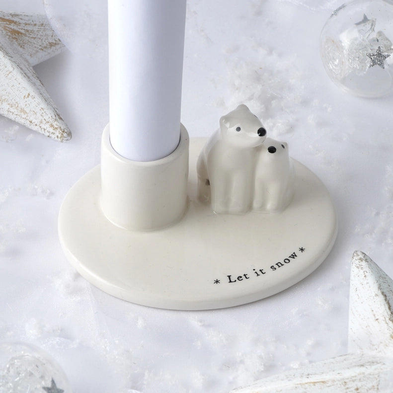 Candle holder with polar bear figures and 'Let it snow' text on a snowy background