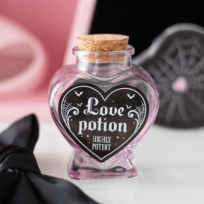 Heart-shaped glass bottle labeled 'Love potion Highly Potent' with a cork lid.