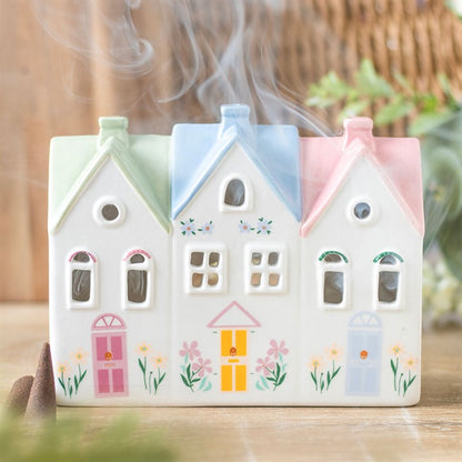 Decorative ceramic house-shaped incense burner with pastel colors and floral designs.