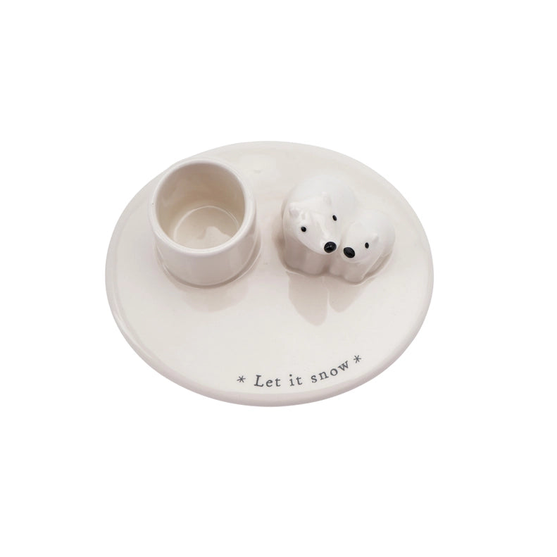 White ceramic holder with two small round containers and a text 'Let it snow' on a white background