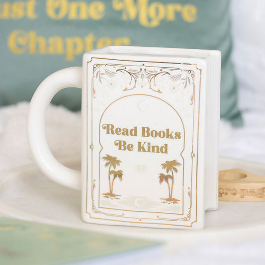 White coffee mug or tea cup with 'Read Books, Be Kind' text and palm golden trees. It can be used as bookish decor as well.