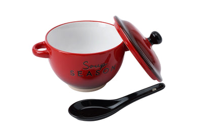 Red ceramic soup tureen with a black spoon on a white background