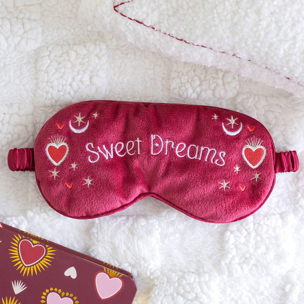 Red sleep mask with 'Sweet Dreams' text, hearts, moons and stars.
