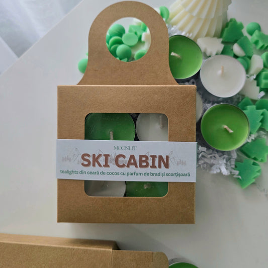 Packaged tealight candles with a 'Ski Cabin' label on a white surface