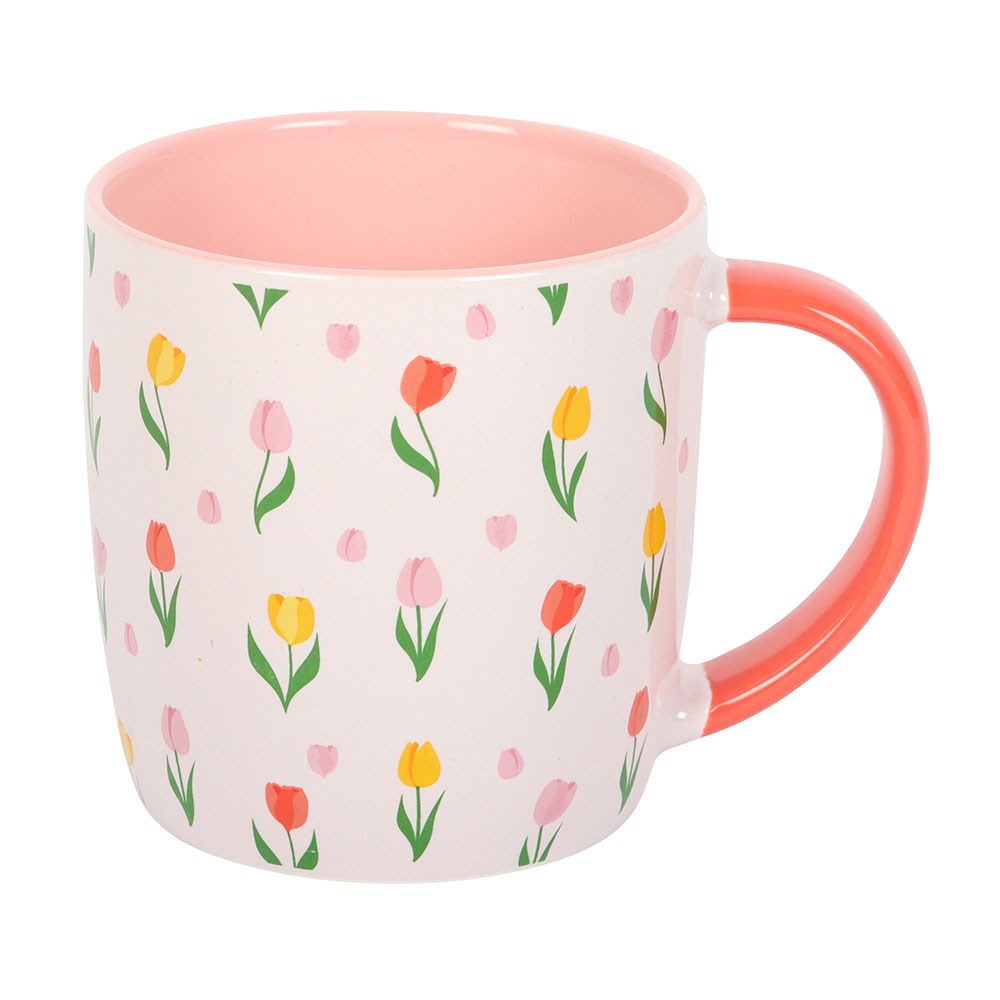 Coffee or tea mug with floral pattern and pink handle. Light pink cup with tulips printed.