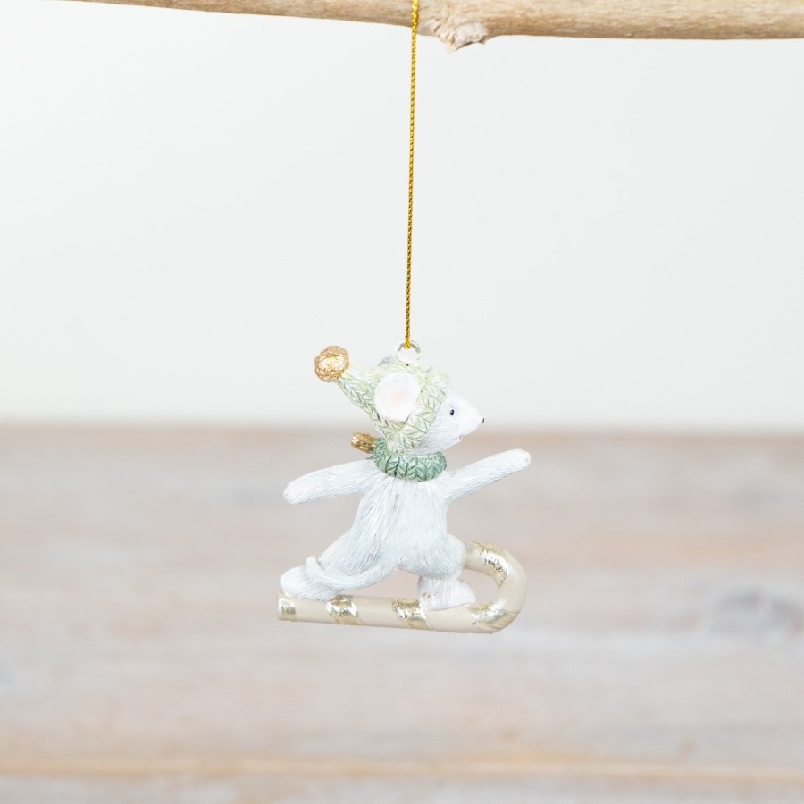 Decorative mouse ornament on a branch with a white background