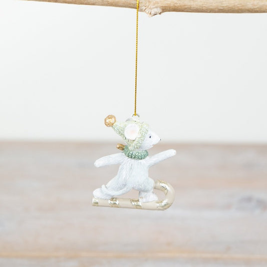 Decorative mouse ornament on a branch with a white background